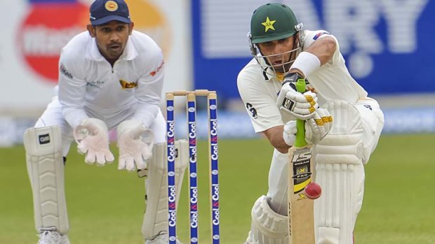 Pakistan captain Misbah-ul Haq plays watchfully foward as Sri Lanka wicketkeeper Prasanna Jayawardene looks on.