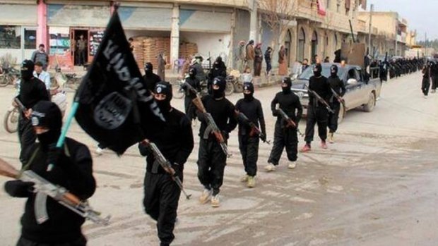 Accused of war crimes ... Islamic State militants march through Raqqa, Syria.