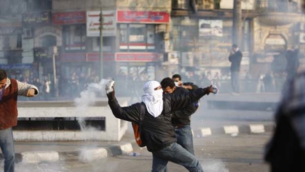A protester throws back a tear gas canister towards police  at a demonstration in Cairo.