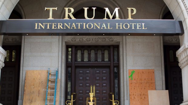 Plywood covers up anti-Trump graffiti at the entrance to his new Washington hotel.