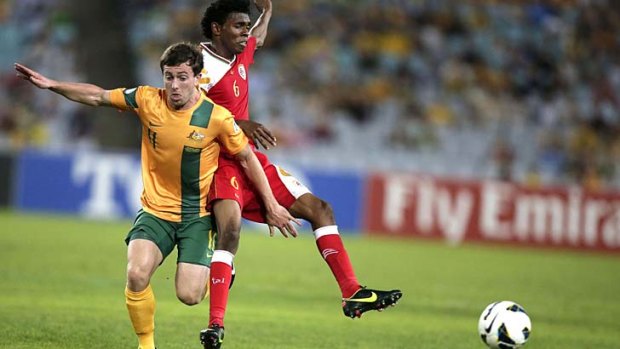 Young star Tommy Oar and Oman's Raed Saleh fight for the ball.
