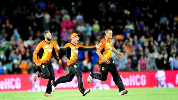 Perth Scorchers players celebrate their thrilling four-wicket victory against the Sydney Sixers at Manuka Oval on Wednesday night.