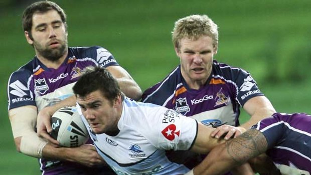 The Storm's Todd Lowrie and skipper Cameron Smith tackle Cronulla's Kade Snowden during Melbourne's 24-4 win at AAMI Park last night.