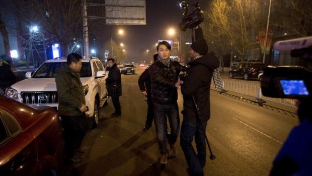 Restricted: Policemen try to prevent journalists from interviewing lawyer Zhang Qingfang, who was inside the white car.
