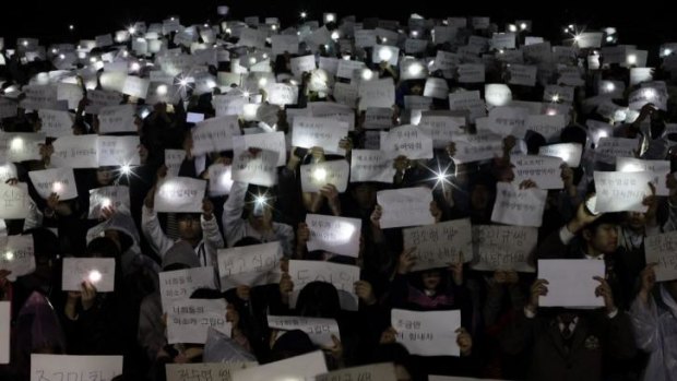 Danwon High School students hold papers with messages such as "miss you", "love you" and "don't lose your hope" for their friends who are missing.