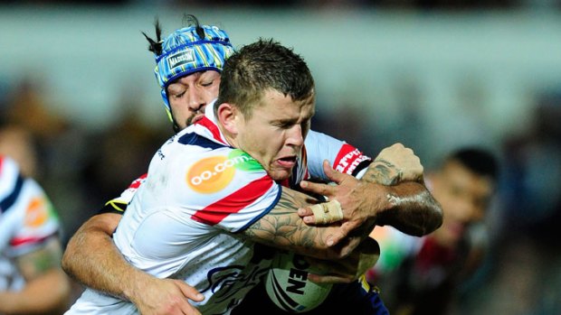 Todd Carney of the Roosters is tackled by the Cowboys' Johnathan Thurston.