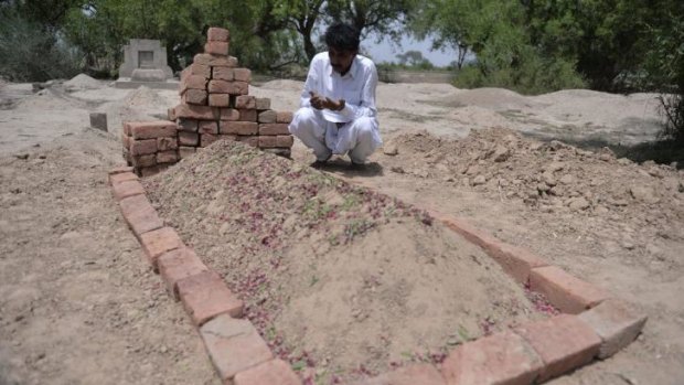 Pakistani resident Mohammad Iqbal prays at the grave of his second wife, Farzana Parveen.