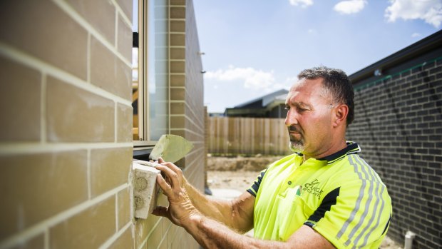 Chris Gianchou lays some of the final bricks for a home in Casey.
