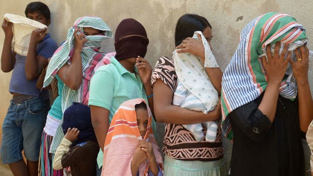 Sri Lankan asylum seekers sent back by Australia queue to enter the magistrate's court in the southern port district of Galle, Sri Lanka, in July.