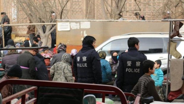 Watchful eye: Police wait outside Hotan Mosque during Friday prayer.