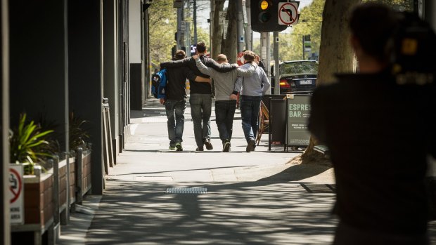 James  Lehane, second from left, is surrounded by friends as he leaves the Melbourne Magistrates' Court.