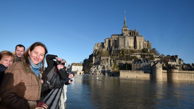 French minister for Ecology, Sustainable Development and Energy, Segolene Royal poses in front of the Mont-Saint-Michel during high tides. 