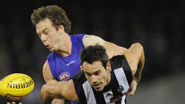 Liam Picken of the Bulldogs and Collingwood's Alan Didak battle for the ball.