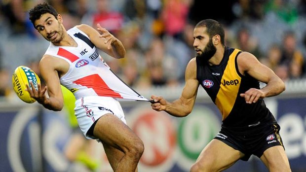 Touchy feely: Tiger Bachar Houli barely gets a hold on Saint Trent Dennis-Lane, who barely gets a hold on the ball.