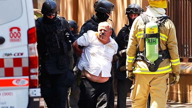 A man whose car was stormed by police outside NSW Parliament House on Friday is taken away.