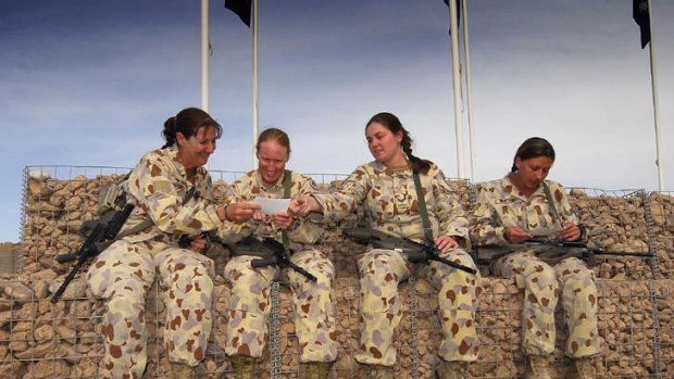Comrades in arms &#8230; Sergeant Donna Bourke, Warrant Officer Cassandra Jones, Corporal Nicole Spohn and Corporal Ivona Bartusch share photos of their children while serving in Afghanistan.
