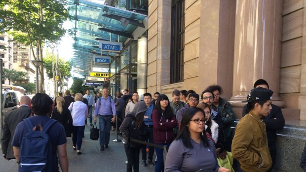 People queue in front of the Queen St Apple store in Brisbane.