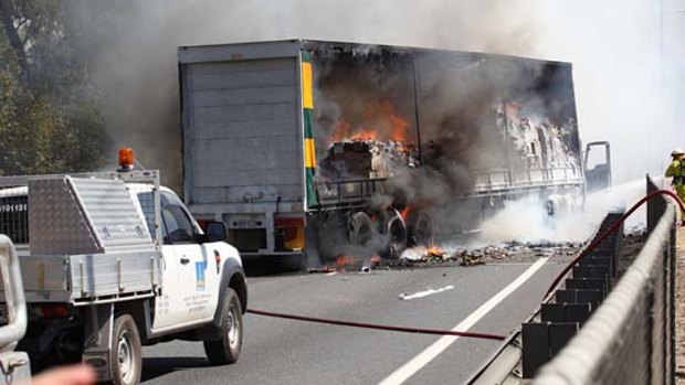 Fire crews battle to bring a furiously burning semi-trailer fire under control on the Gateway Motorway.