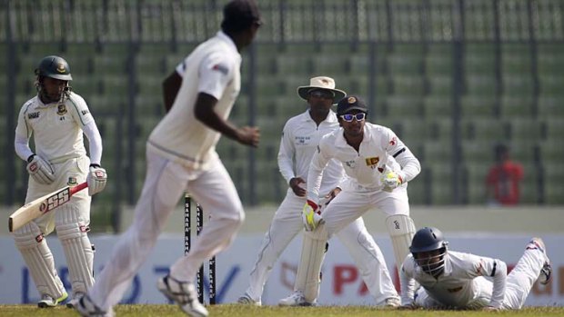 Sri Lanka's Kaushal Silva (right) dives to try and take a catch offered by Bangladesh captain Mushfiqur Rahim (left) as Sri Lanka's wicketkeeper Dinesh Chandimal (second right) and Mahela Jayawardene (third right) look on.