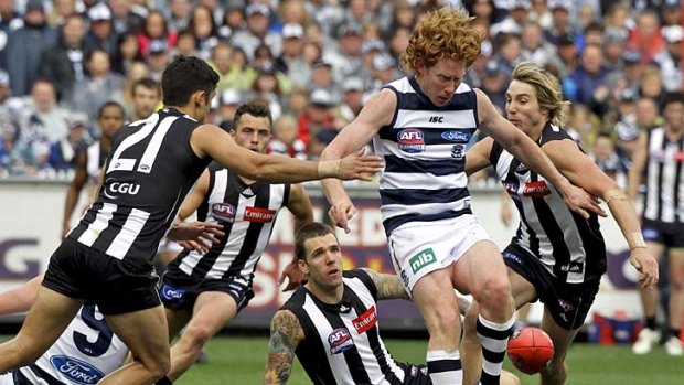 Cats on the warpath: Cameron Ling bursts free of a pack of Magpies.