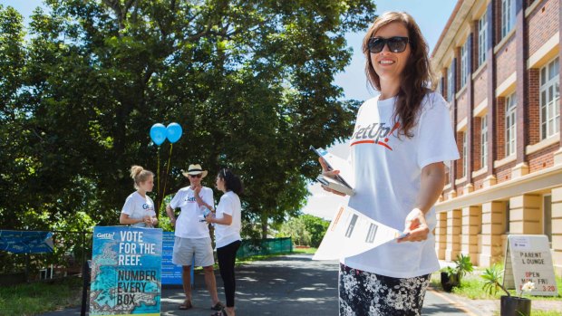 A volunteer from activist group GetUp! hands out how-to-vote cards as locals hit the polling booths in 2015.