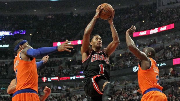Chicacgo star Derrick Rose drives to the basket between Carmelo Anthony and Raymond Felton of the New York Knicks at the United Center.
