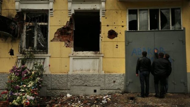 Attacked: Men inspect the ruins of the central police station  in Mariupol.