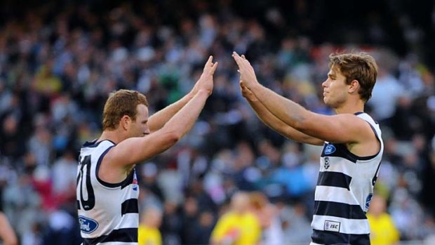 High fives: Steve Johnson (left) celebrates a goal he kicked after receiving a cheeky handball from Tom Hawkins.