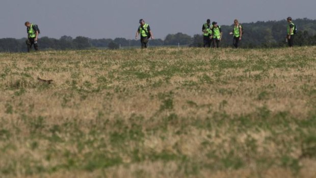 Australian and Dutch experts examine the area of the Malaysia Airlines Flight 17 plane crash near the village of Rossipne in the Donetsk region in eastern Ukraine.