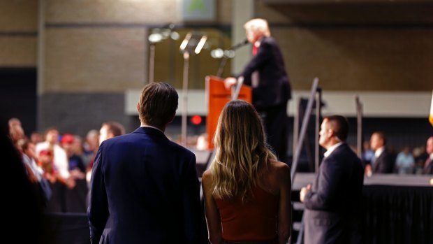Eric Trump, foreground, son of Republican presidential candidate Donald Trump, listens as his father delivers a campaign speech in Charlotte, North Carolina.