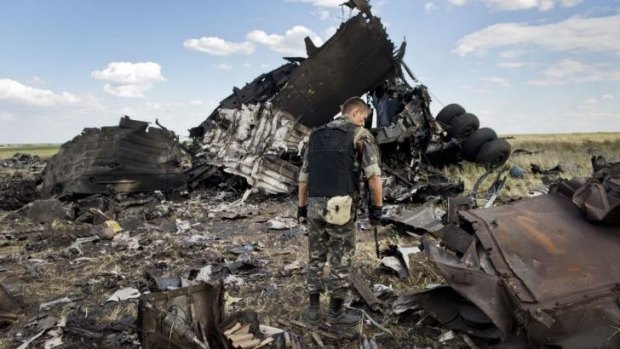 A member of pro-Russian separatist forces looks through the debris on the outskirts of Luhansk.