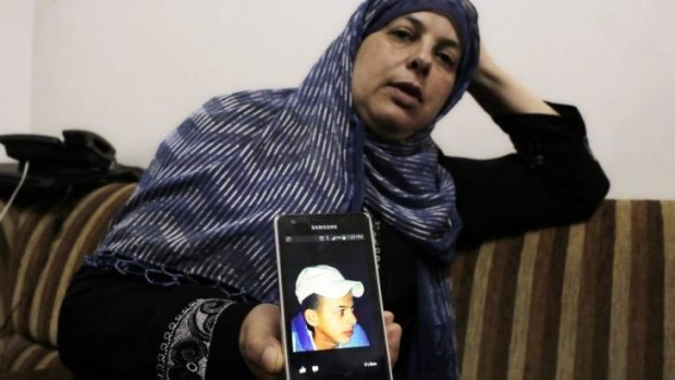 Suha, mother of murdered Palestinian teenager, Muhammad Hussein Abu Khdeir, shows a picture of her son on her mobile phone at their home in Shuafat, East Jerusalem.