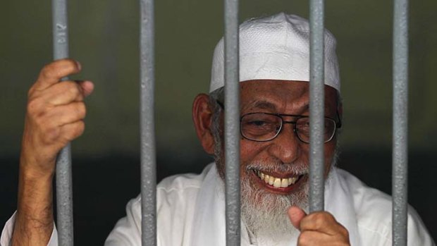 Faces life ... Abu Bakar Bashir smiles from his cell before his trial in a Jakarta court.