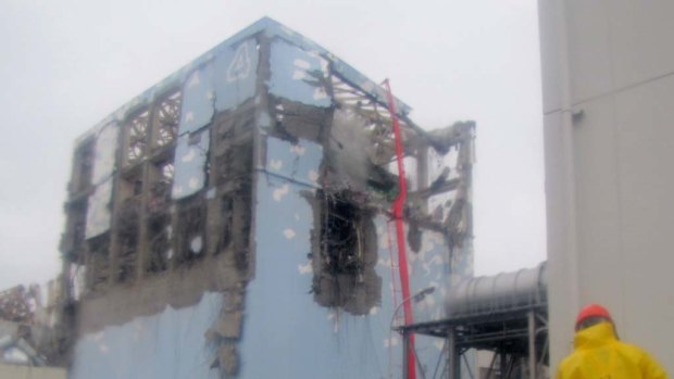 Workers in protective suits at the damaged No. 4 unit of the Fukushima Dai-ichi nuclear complex.