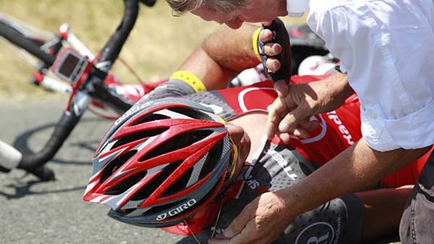 Tour de France doctor Gerard Porte tends to Yaroslav Popovych of the Ukraine after he crashed.