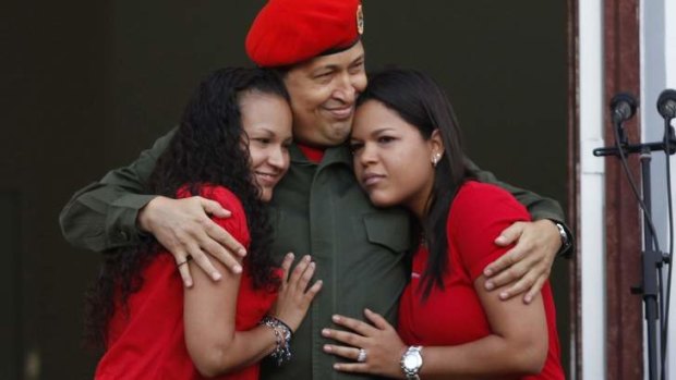 Hugo Chavez hugs his daughters Rosa and Maria.