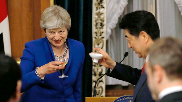 British Prime Minister Theresa May toasts with  Japanese PM Shinzo Abe at the opening of a welcome dinner at Akasaka Palace state guesthouse in Tokyo, on Thursday.