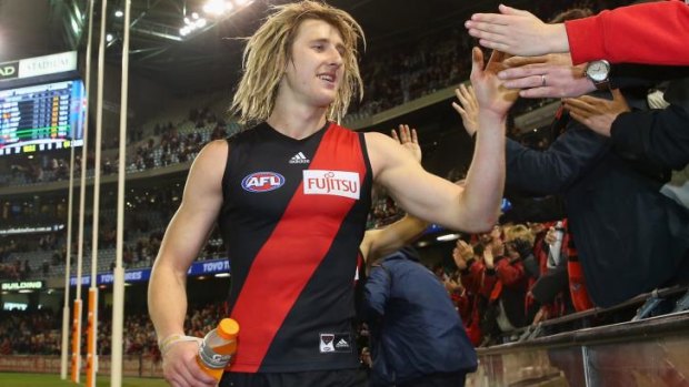 Dyson Heppell of the Bombers high-fives fans after the game.