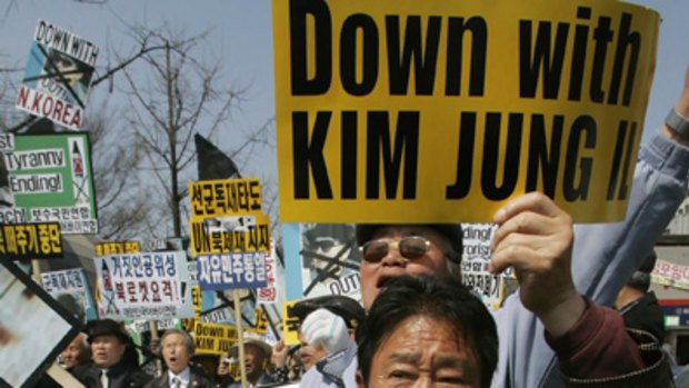 A protester holds portraits of US journalists Euna Lee, right, and Laura Ling.