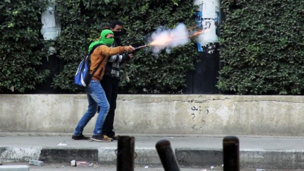 Clashes: A Muslim Brotherhood supporter aims fireworks at supporters of the Egyptian government in Cairo.  