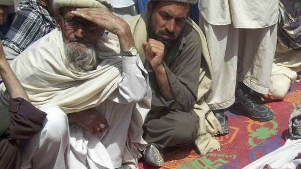 Afghan villagers mourn near the bodies of children they said  were killed in the air strike.