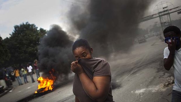 Violence spreads ...   smoke pours from tyres set alight by demonstrators in Port-au-Prince.