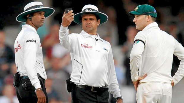 Australian captain Michael Clarke remonstrates with umpires Aleem Dar (C) and Kumar Dharmasena before the officials ended play.