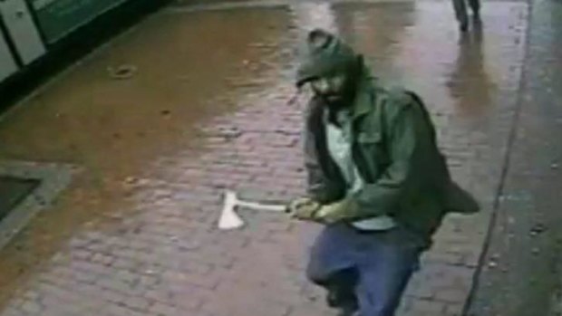 On attack: A man identified at Zale Thompson approaches police officers with a hatchet in the Queens borough of New York. 