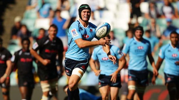 Having a  ball ... Berrick Barnes passes in the Waratahs’ nail-biting victory against the Sharks at Allianz Stadium on Saturday. The team will look to build on their second win of the year when they line up against the Chiefs.