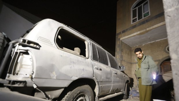 A Houthi militant checks the site of a bomb explosion near a military academy in Sanaa on Monday. A French woman and her driver were abducted at gunpoint in the capital on Tuesday, according to reports.