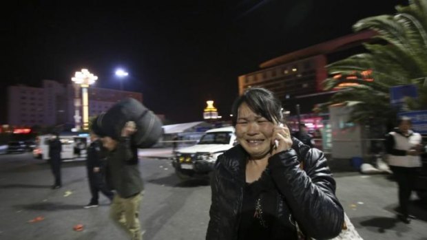 A woman reacts, at the crime scene outside a railway station after an attack, in Kunming, in southwestern China's Yunnan province.