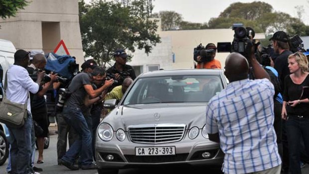 Journalists surround the car of a relative of former South African President Nelson Mandela at Milpark Hospital in Johannesburg.