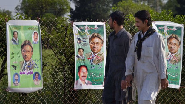 Poster boy: Pakistanis look at election posters for General Pervez Musharraf on the outskirts of Islamabad.