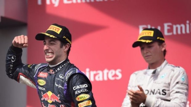 Daniel Ricciardo celebrates on the podium after his maiden victory in formula one.